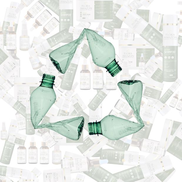 recycling logo formed by plastic bottles with flora amazon products in the background.