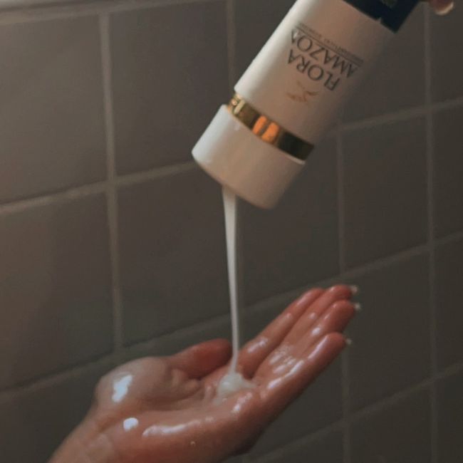 ozone therapy shampoo by flora amazon being poured onto a hand in the shower. 